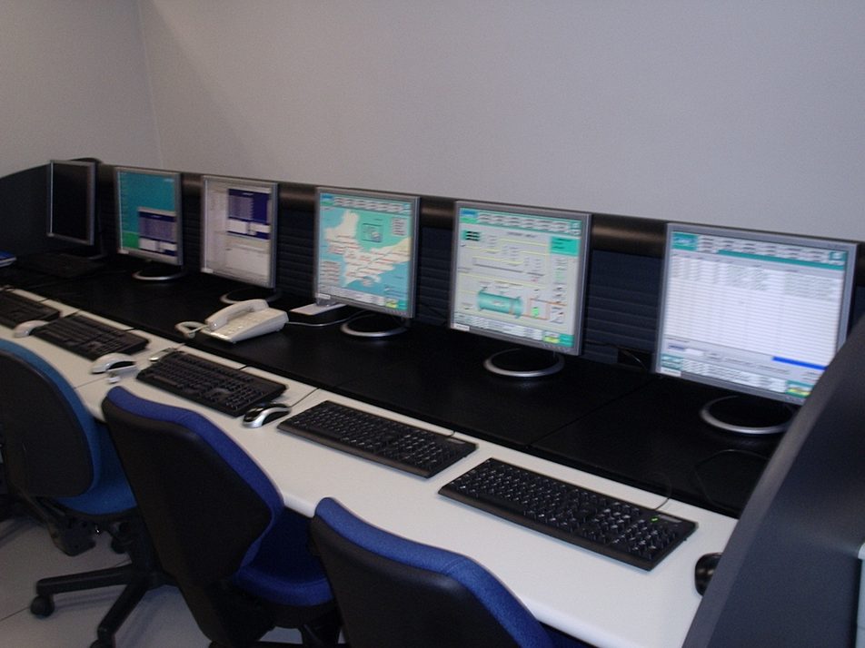 Operator workstations with SCADA screens in the Comgás control room